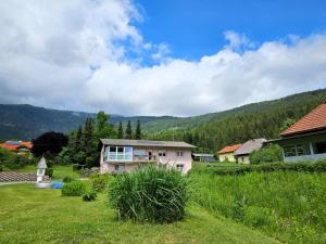 a house in the middle of a grassy field at Mangartblick in Arriach