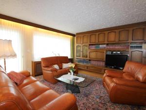 a living room with leather furniture and a television at Mangartblick in Arriach +23 photos