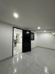 a empty room with a black door and a white tile floor at Island Ease Villa in Willemstad