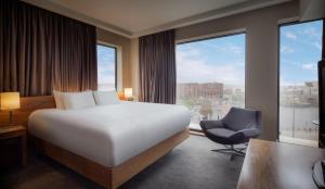 a hotel room with a bed and a chair and window at Hilton Liverpool City Centre in Liverpool
