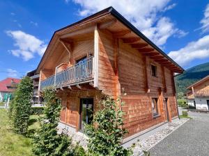 a log house with a balcony on the side of it at Rattendorf 1A in Rattendorf