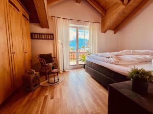a bedroom with a bed and a window and a chair at Casa Nostra in Kötschach
