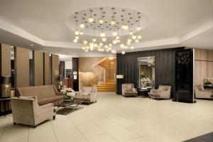 a lobby with couches and chairs and a chandelier at DoubleTree by Hilton Luxembourg in Luxembourg