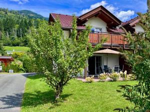 a house with a tree on the side of the road at Casa Nostra in Kötschach