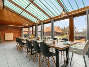 a conservatory with a long table and chairs at De Marckhoeve in Merksplas