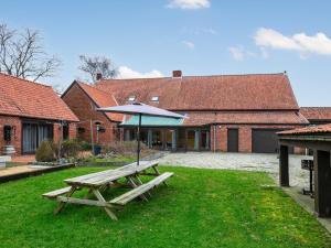 a picnic table with an umbrella in front of a building at De Marckhoeve in Merksplas