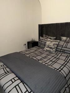 a bedroom with a large black and white bed at City Home in Liverpool