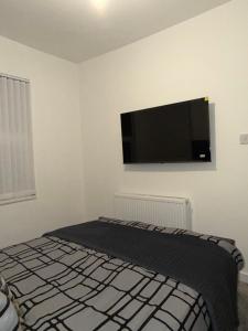 a bedroom with a flat screen tv on the wall at City Home in Liverpool +4 photos