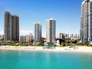 a beach in front of a city with tall buildings at DoubleTree by Hilton Ocean Point Resort - North Miami Beach in Miami Beach