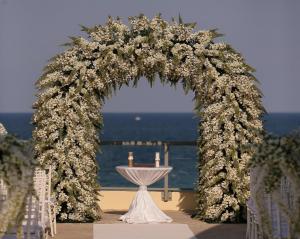 an arch with white flowers and candles on a table at DoubleTree by Hilton Ocean Point Resort - North Miami Beach in Miami Beach +51 photos