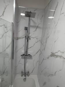 a bathroom with a shower with white marble walls at City Home in Liverpool
