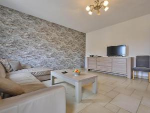 a living room with a couch and a tv at Quanto A in Geetbets