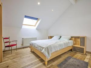 a bedroom with a bed and a red chair at Quanto A in Geetbets