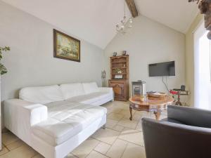 a living room with a white couch and a table at Quanto B in Geetbets