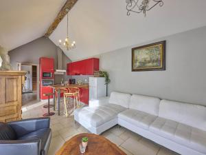 a living room with a white couch and a kitchen at Quanto B in Geetbets