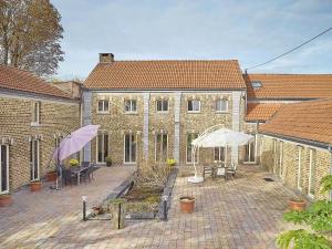 a brick building with tables and umbrellas in a courtyard at Quanto B in Geetbets