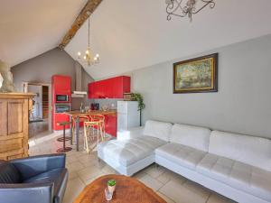 a living room with a white couch and a kitchen at Quanto A B in Geetbets