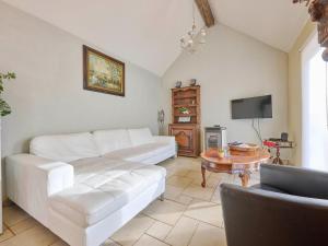 a living room with a white couch and a table at Quanto A B in Geetbets