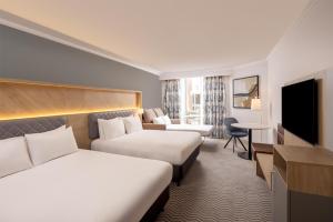 a hotel room with two beds and a television at Hilton Northampton Hotel in Northampton +78 photos