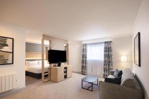 a hotel room with a couch and a bed at Hilton Northampton Hotel in Northampton