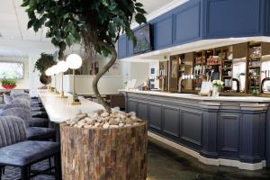 a bar in a restaurant with blue cabinets at Hilton Northampton Hotel in Northampton