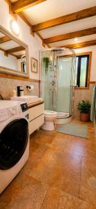 a bathroom with a shower and a washing machine at Casa Rosa in Coñaripe +8 photos