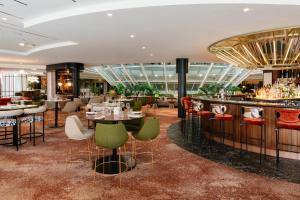 a restaurant with tables and chairs and a bar at Hilton Paris La Défense in Puteaux