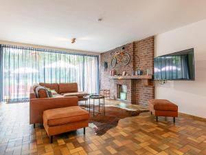 a living room with a couch and a tv at Maison Clement in Maasmechelen