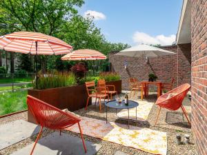 a patio with chairs and tables and umbrellas at Maison Clement in Maasmechelen