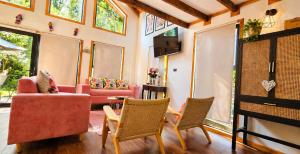 a living room with pink furniture and windows at Casa Rosa in Coñaripe