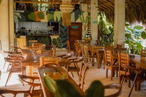 an empty restaurant with wooden tables and chairs at MAKAI BEACH HOSTEL in Punta de Piedra