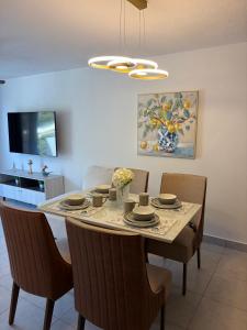 a dining room with a table with chairs and a dining room at Modern top floor apartment with pool in San Marcos