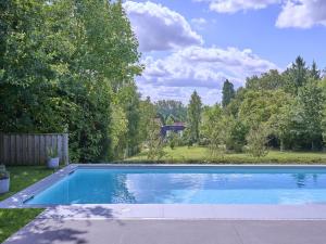 a large blue swimming pool in a yard at Maison Oscar in Tongeren
