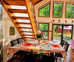 a dining room with a table with a vase of flowers at Casa Rosa in Coñaripe