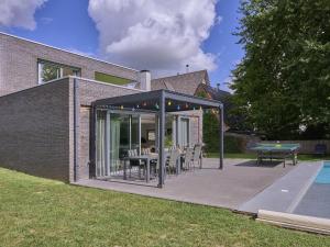 a pavilion with a table and chairs in a backyard at Maison Oscar in Tongeren