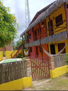 a yellow and orange house with a fence at Flatmoitas in Amontada +2 photos
