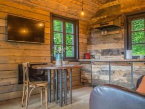 a kitchen with a table and a tv in a cabin at Be Chalet in Ferrières