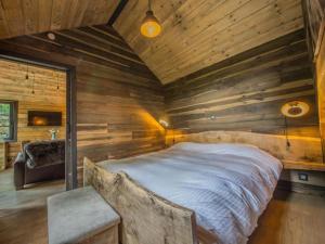 a bedroom with a large bed in a wooden wall at Be Chalet in Ferrières