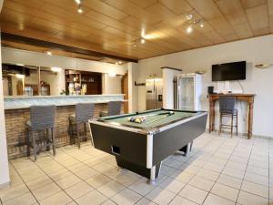 a pool table in a room with a bar at Le GitAnne in Sourbrodt