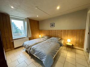 a bedroom with a bed and a window and two lamps at Le GitAnne in Sourbrodt +41 photos
