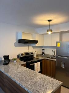 a kitchen with a stove and a counter top at Modern top floor apartment with pool in San Marcos