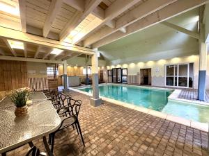 a swimming pool with a table and chairs next to it at Le GitAnne in Sourbrodt