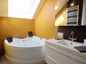 a bathroom with a large tub and a sink at Villa Belvedère in Houffalize +49 photos