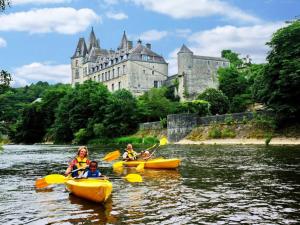 a group of people kayaking on the river in front of a castle at Villa Belvedère in Houffalize