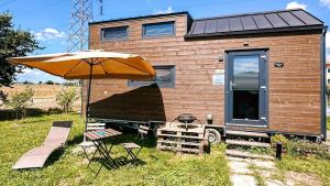 a house with a table and an umbrella and chairs at Dolce Casa 2 by Tiny Away in Rigutino