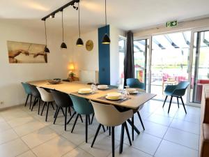 a dining room with a large wooden table and chairs at Villa Belvedère in Houffalize