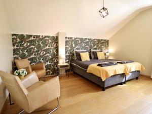 a bedroom with a bed and a chair at Villa Belvedère in Houffalize