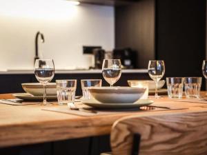 a wooden table with wine glasses and plates on it at Be Durbuy in Durbuy