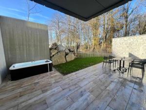 a patio with a hot tub and a table and chairs at Be Durbuy in Durbuy