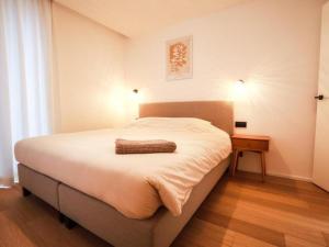 a bedroom with a large white bed and a table at Be Durbuy in Durbuy